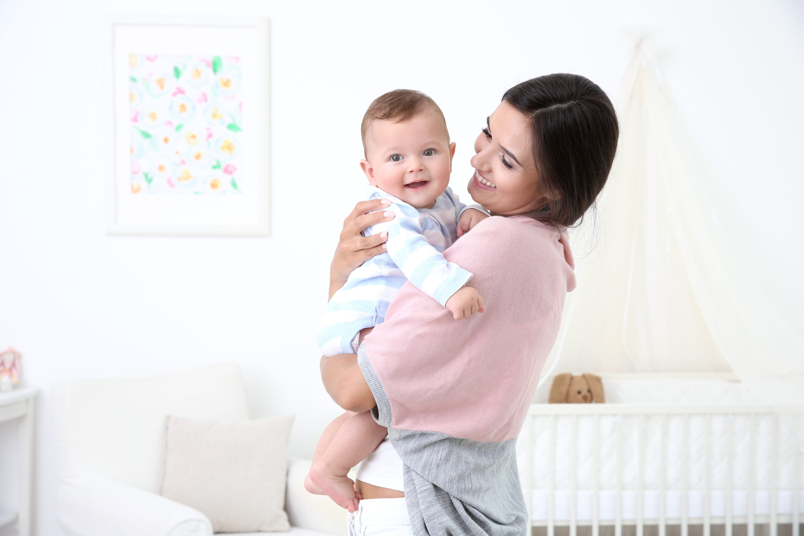 Mother holding cute baby after bathing at home